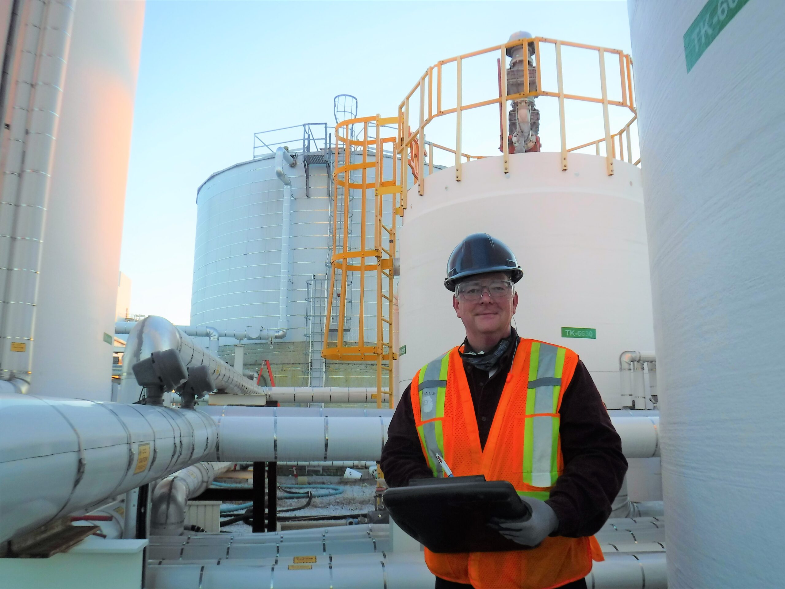 Picture - A man in front of biogas tanks.